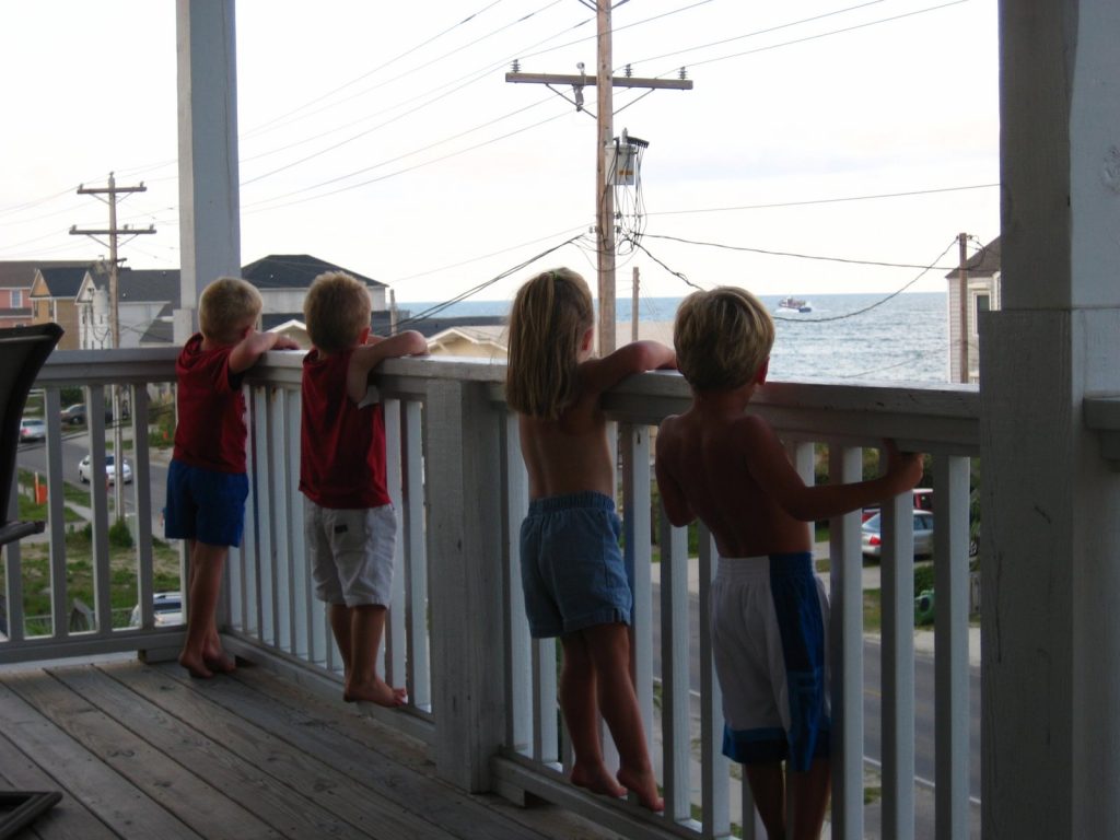 Kids looking over railing at the beach