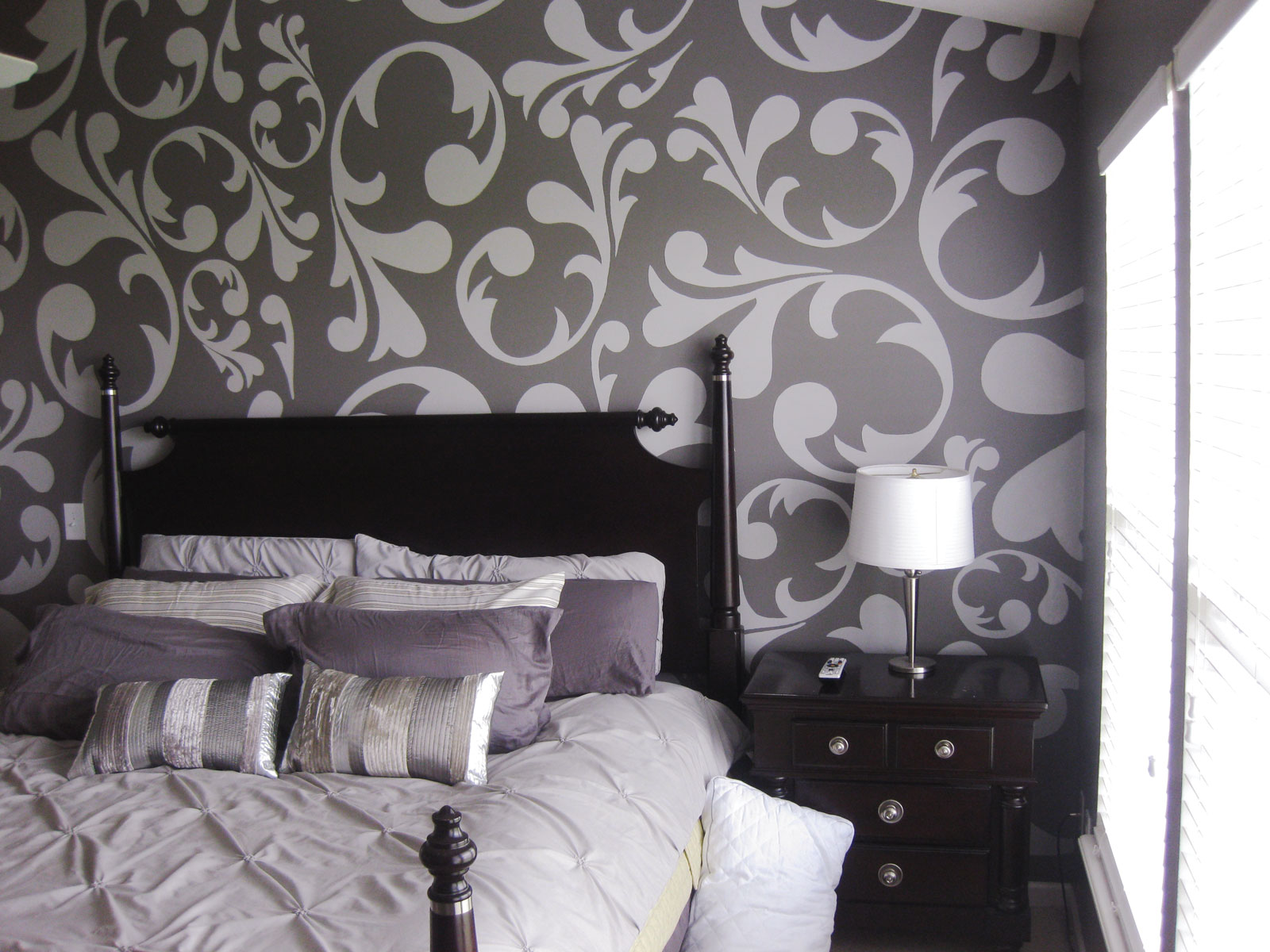 Light gray on gray floral mural on wall behind bed